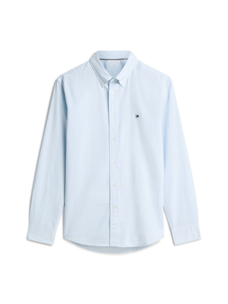 A light blue long-sleeve button-down shirt with a small embroidered Tommy Hilfiger flag logo on the left chest, displayed on a clean white background.