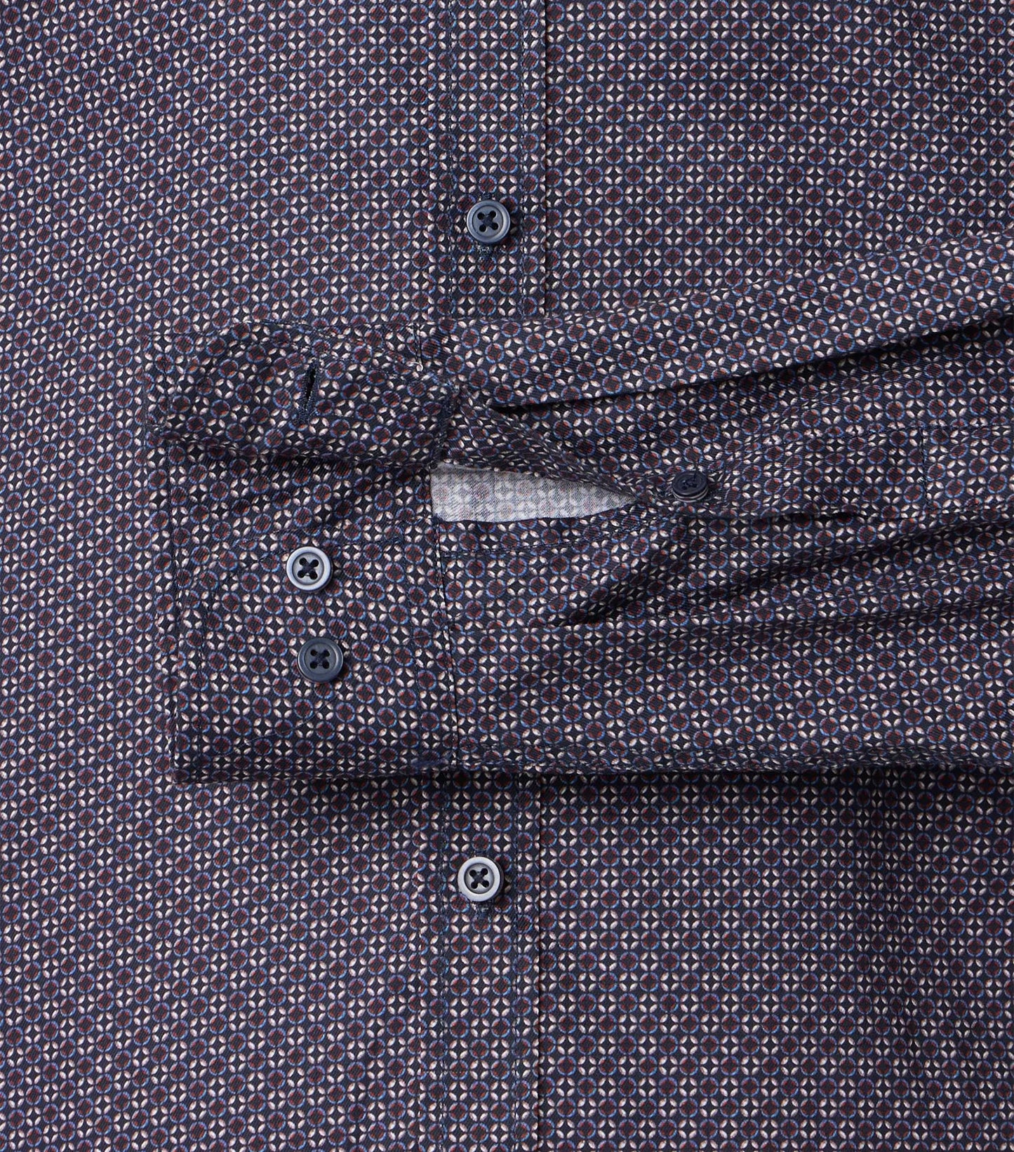 Close-up of a patterned shirt with sleeve cuff and buttons.