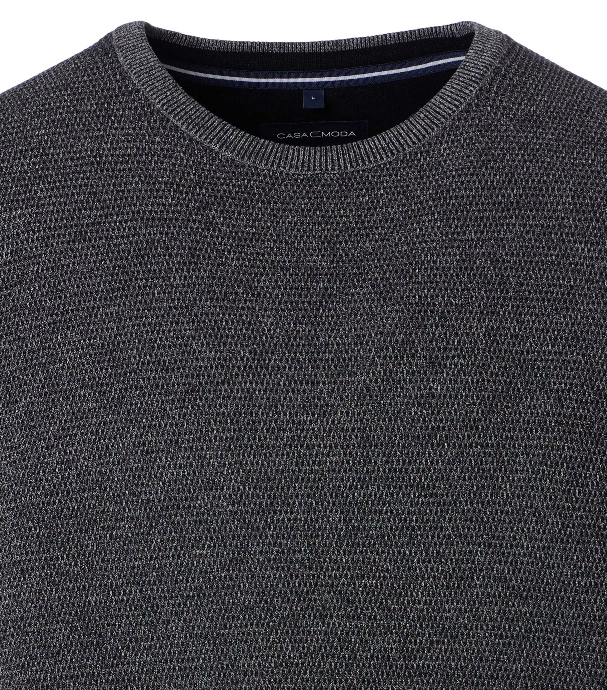 Close-up of a dark gray sweater with 'CasaModa' branding.
