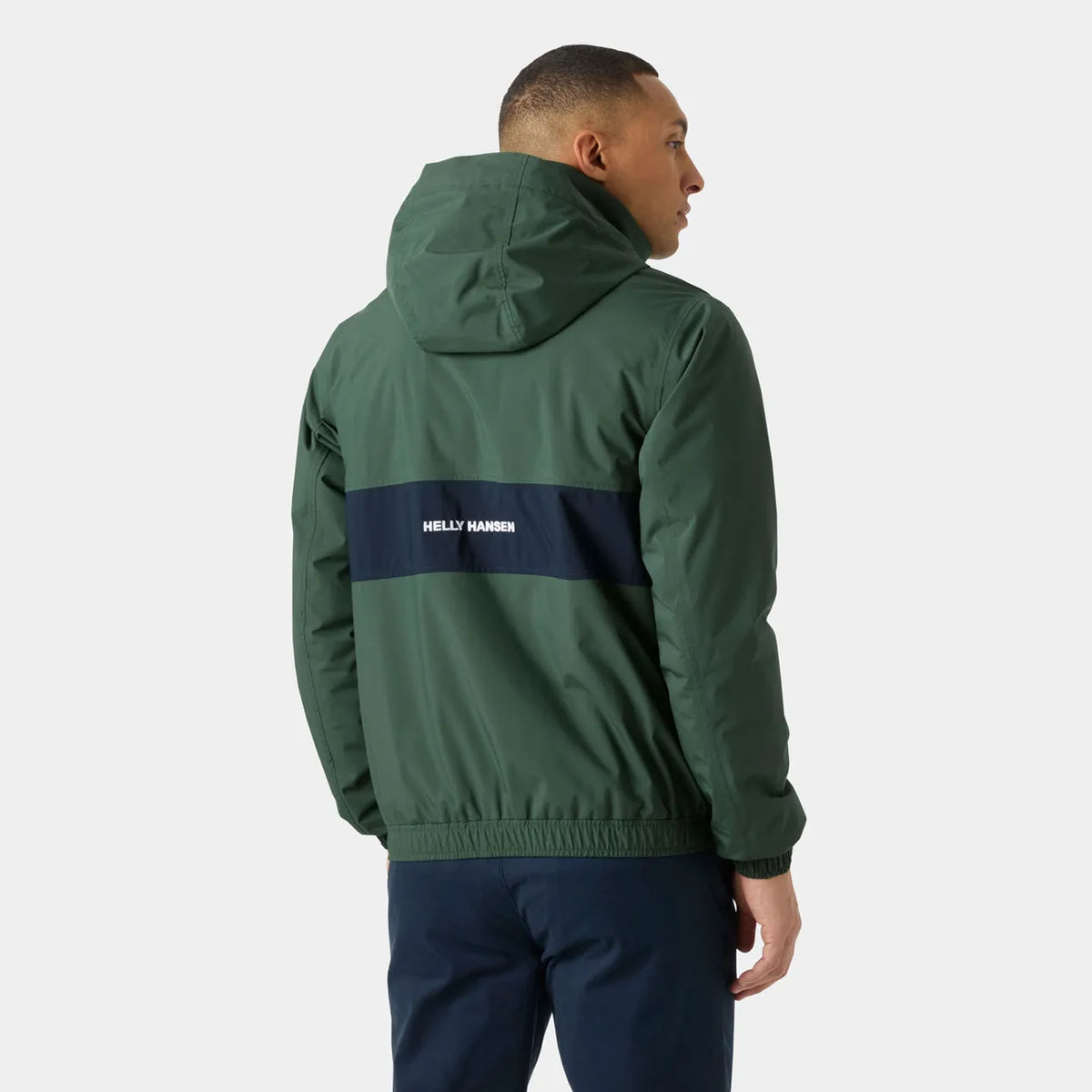 A man shown from the back wearing a dark green hooded jacket with a navy blue horizontal stripe across the upper back featuring the white text 'HELLY HANSEN'.