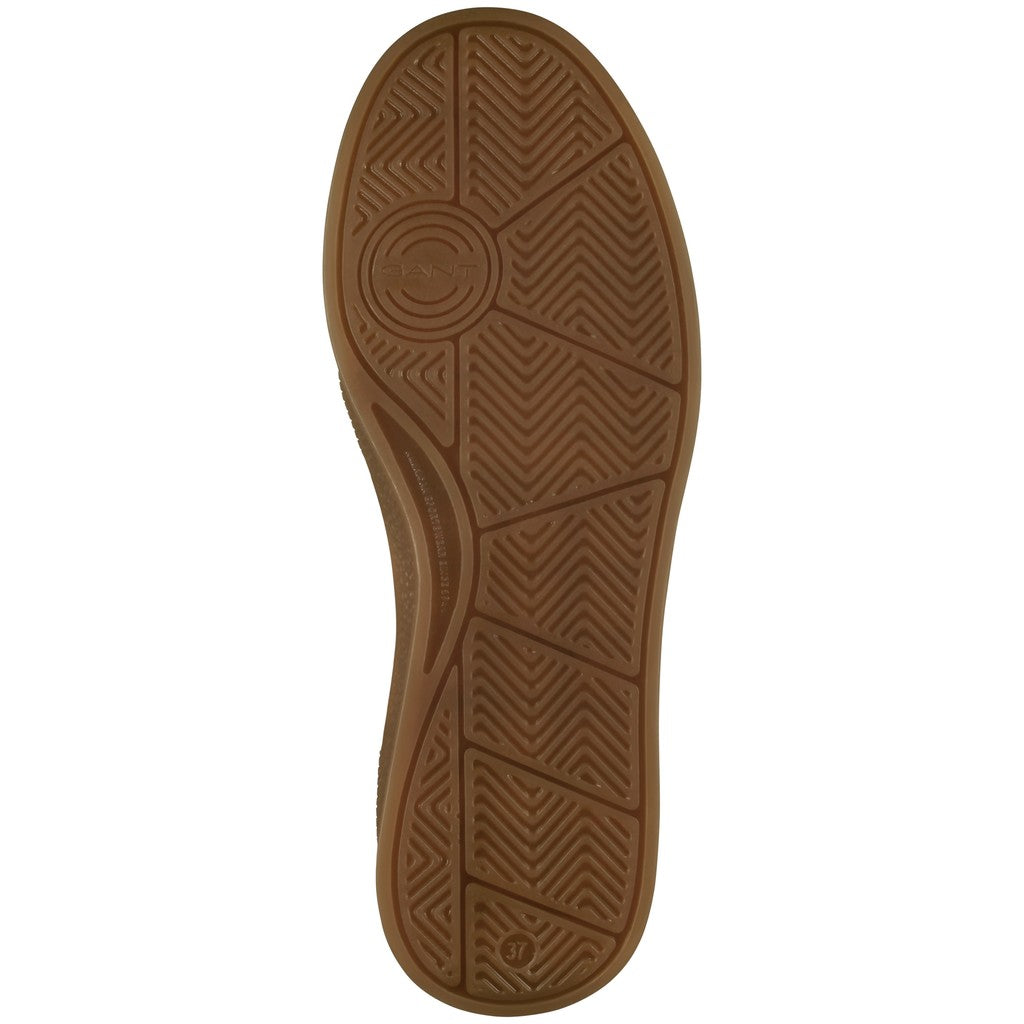 A close-up, top-down view of a brown rubber shoe sole with textured tread patterns, shown against a plain white background.