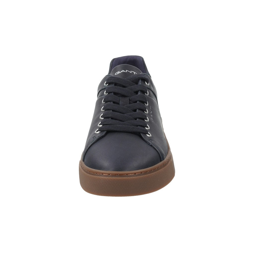 A single GANT low-top sneaker shown from the front on a solid white background. The shoe features a dark navy blue leather upper, matching navy laces, and a contrasting brown gum sole.