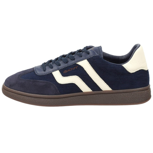 A navy blue suede and corduroy sneaker with white side stripes, a white heel tab, and a brown textured rubber sole, shown in a side profile on a white background.