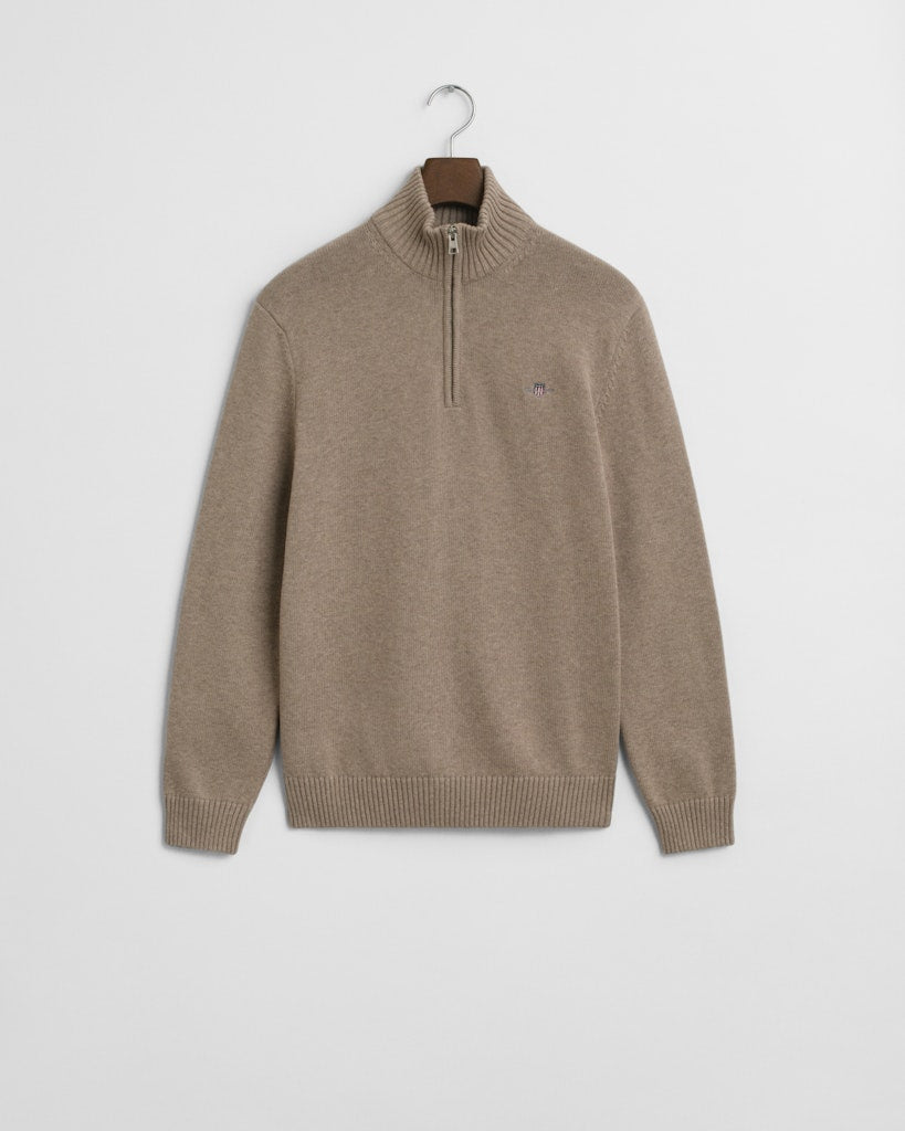 Beige sweater with small GANT logo on a hanger against a light gray background