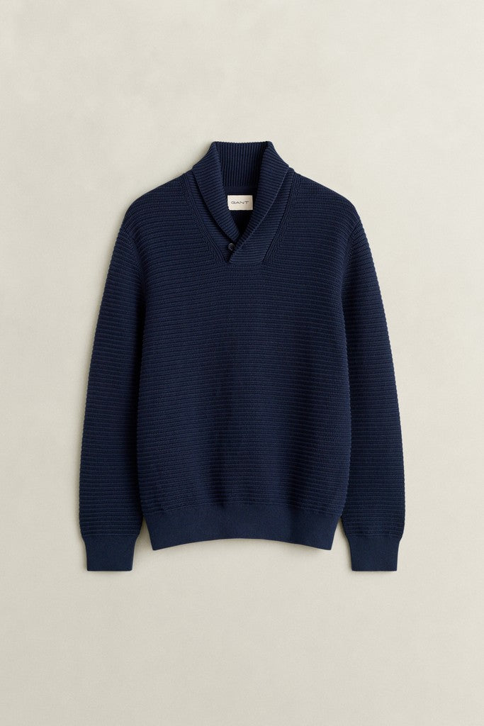 A navy blue ribbed knit sweater with a mock neck collar, displayed flat against a light beige textured background.
