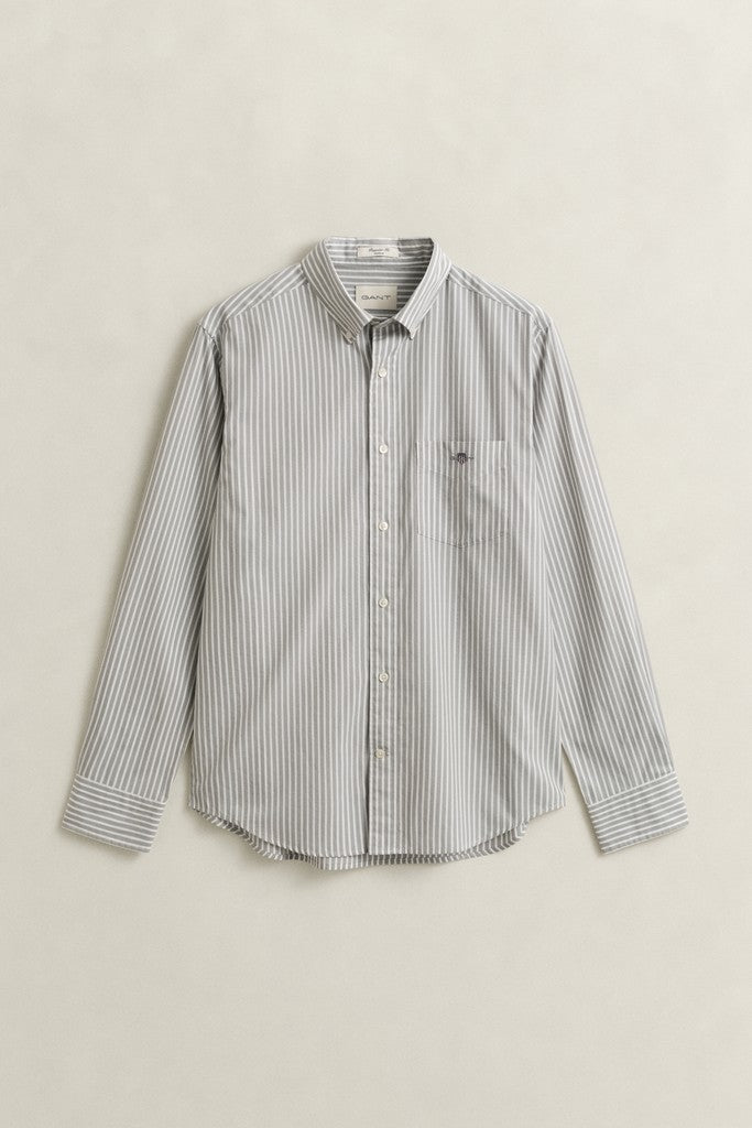 A long-sleeve button-down shirt with vertical gray and white stripes, featuring a classic collar, button-up front, and a single chest pocket, displayed flat against a light beige background.
