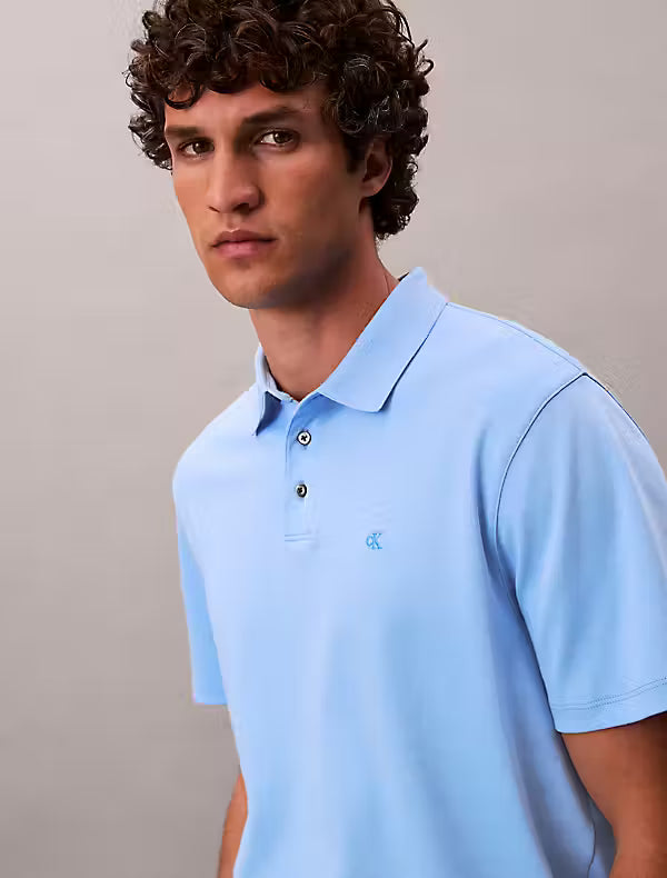 Calvin Klein Supima Cotton Polo. Man wearing a blue Calvin Klein polo on a grey background - Matt O'Brien Fashions