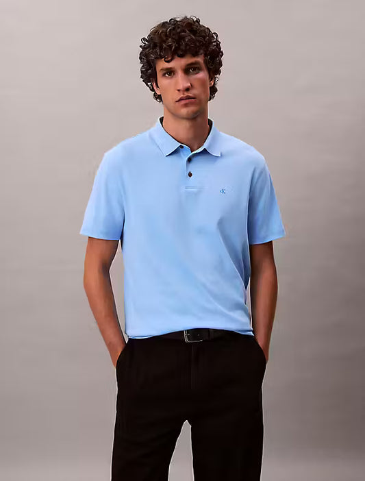 Calvin Klein Supima Cotton Polo. Man wearing a blue polo with CK logo on the chest and black trousers - Matt O'Brien Fashions