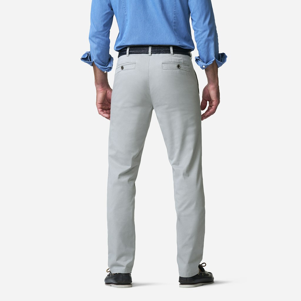 Person wearing light gray pants and a blue shirt on a white background