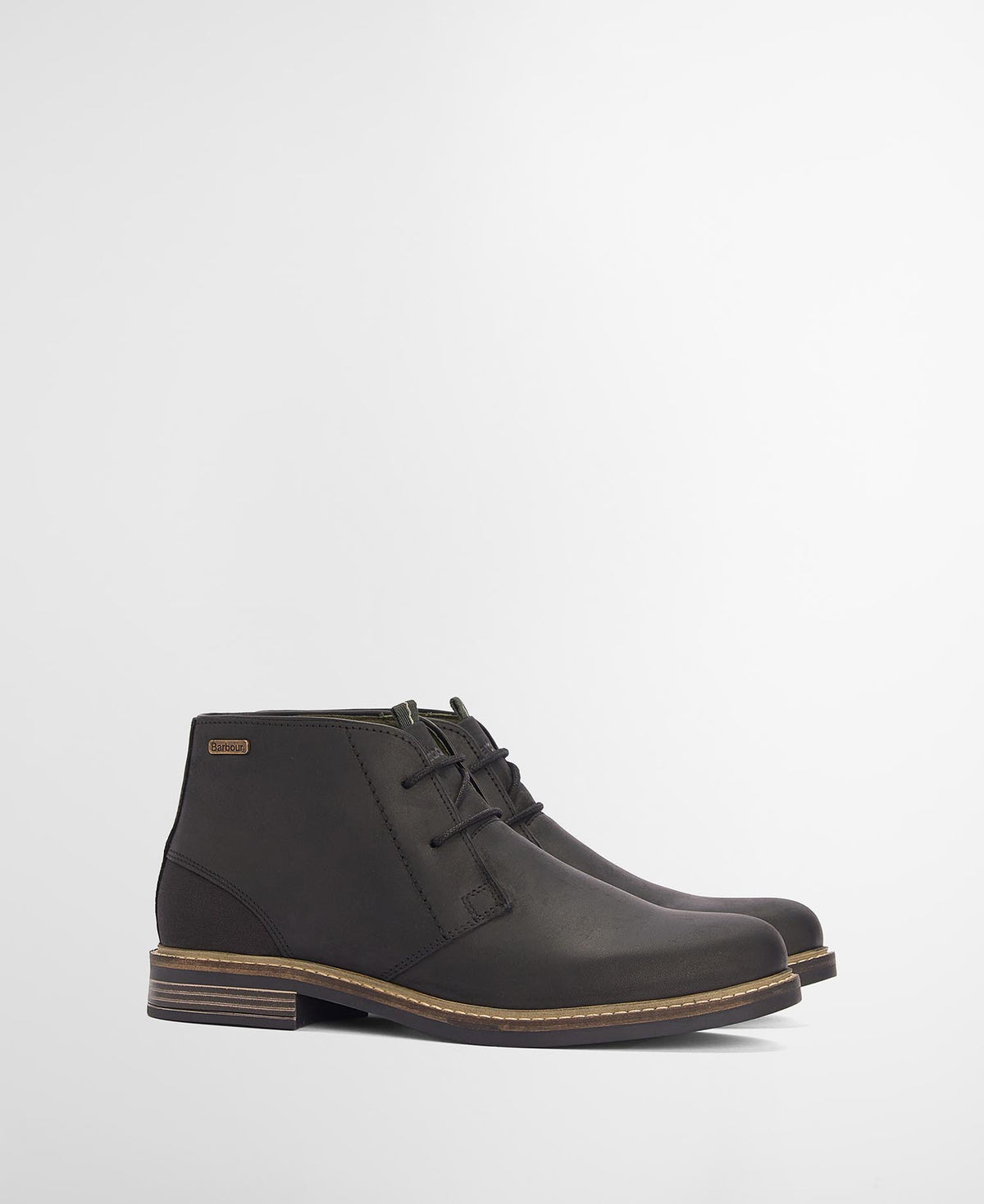 Pair of black leather boots on a light gray background