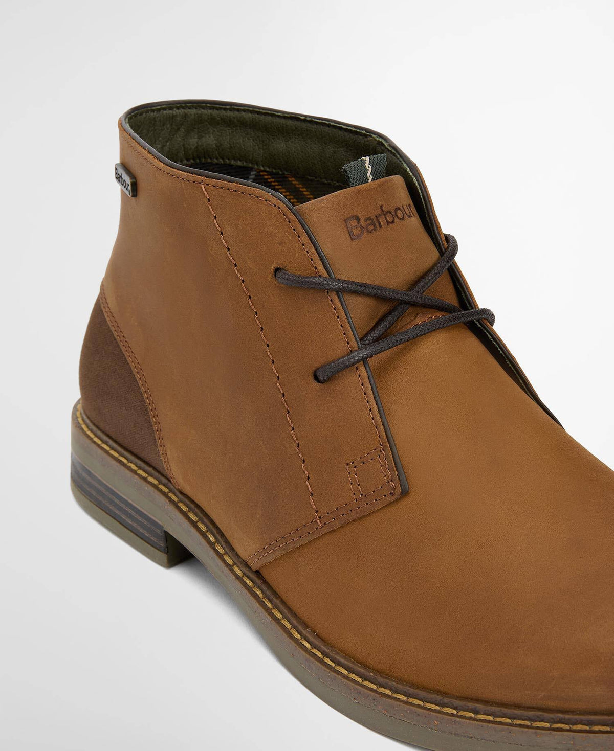 Brown leather boot with laces and Barbour logo on a light gray background