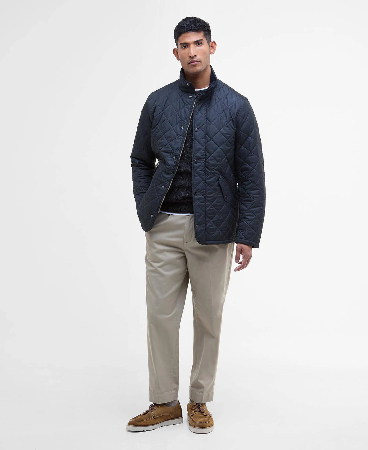 Man wearing a dark blue quilted jacket on a white background