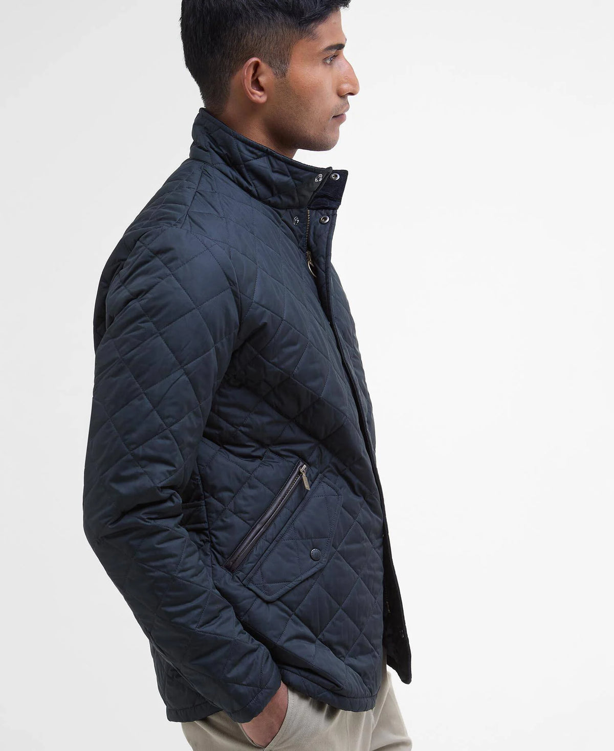 Man wearing a navy quilted jacket on a white background