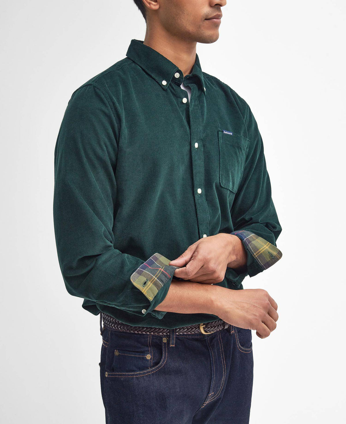 Man wearing a green shirt with plaid cuffs on a white background