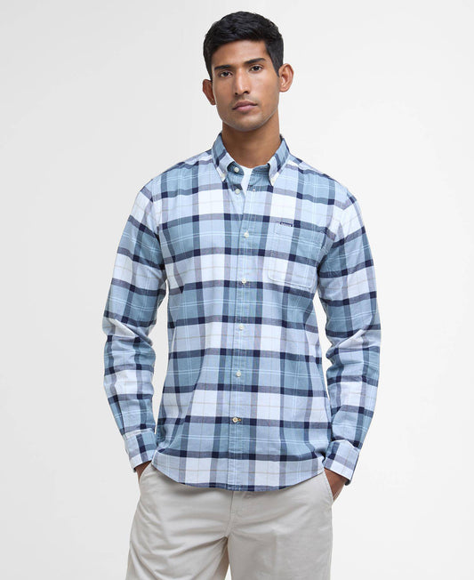 Man wearing a blue and white plaid shirt on a light gray background