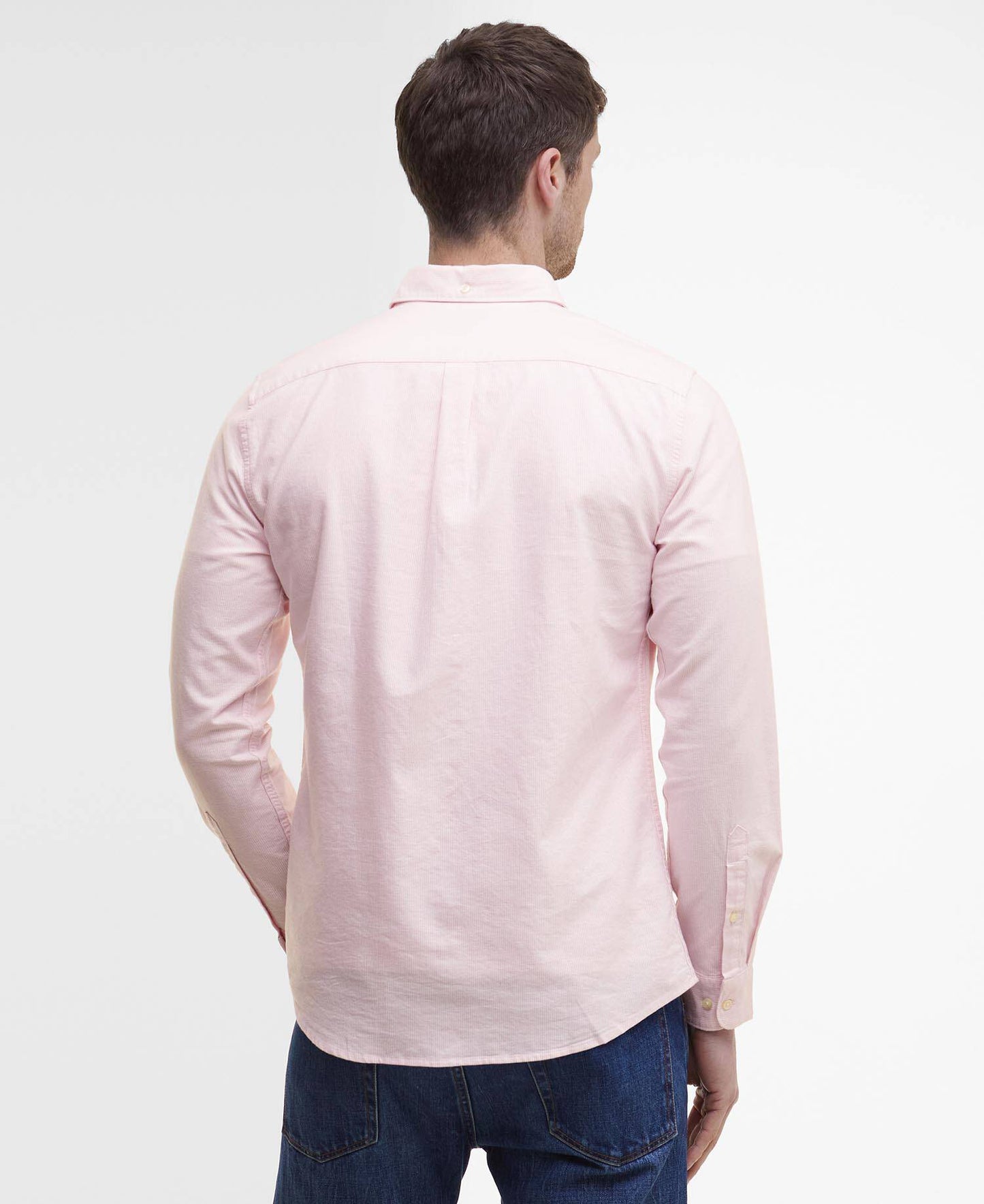 Man wearing a light pink long-sleeve shirt on a white background