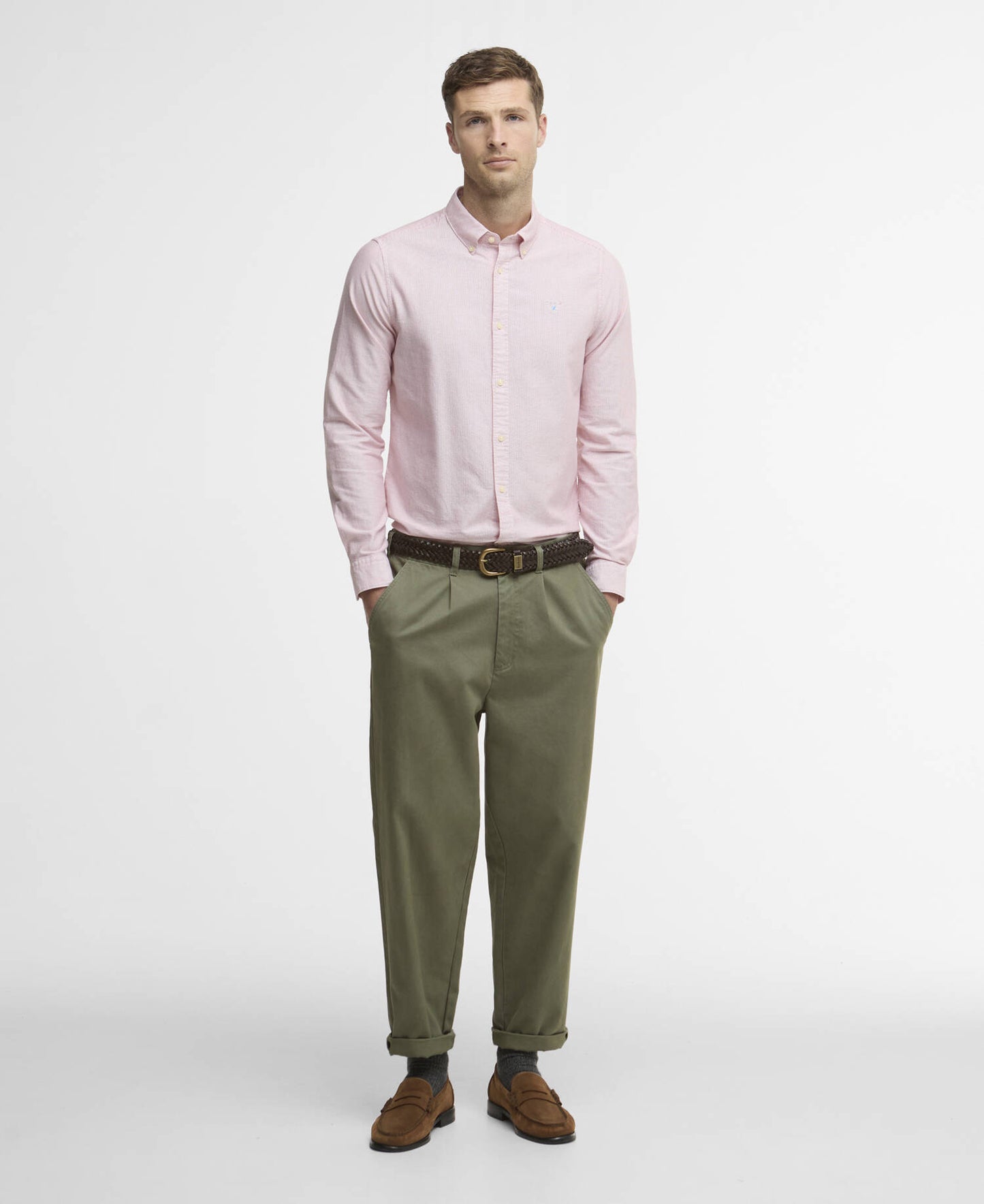 Man wearing a red striped shirt and green pants on a white background