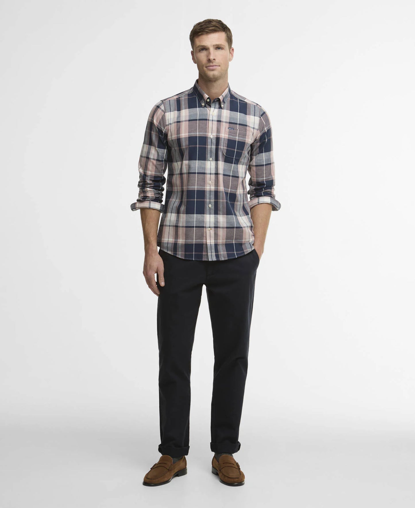Man wearing a plaid shirt and black pants on a white background