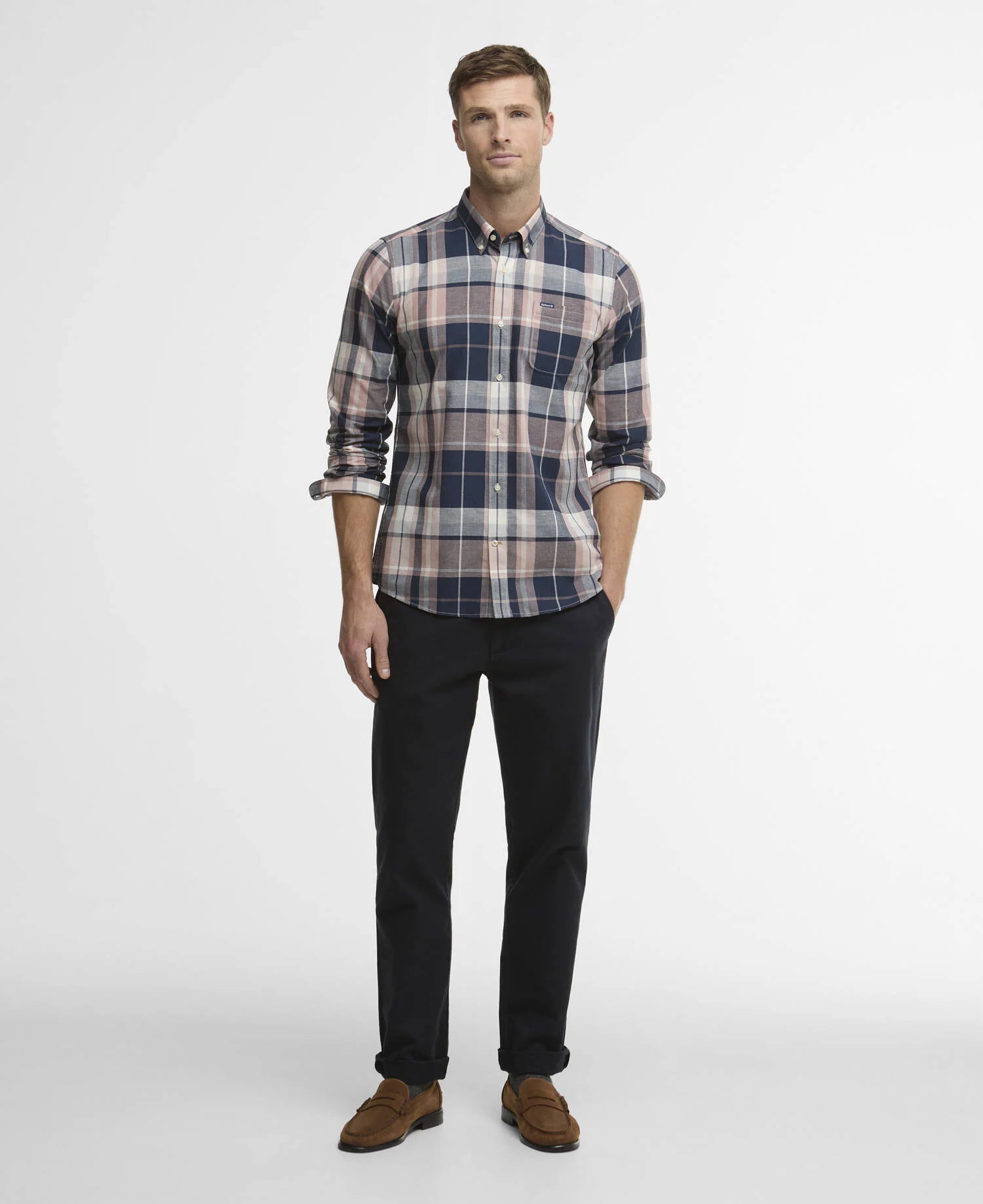 Man wearing a plaid shirt and black pants on a white background