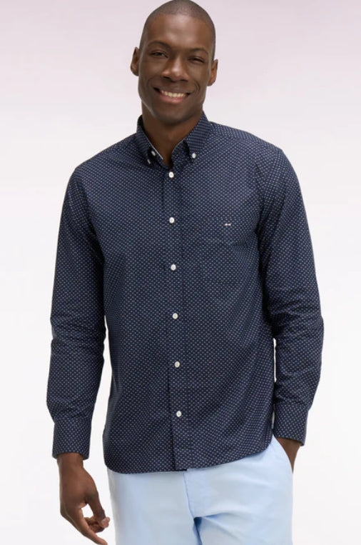 Man wearing a navy patterned shirt with a white background
