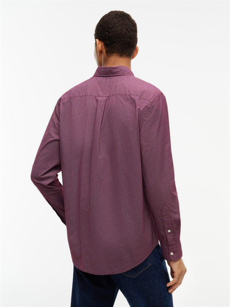 A man viewed from the back wearing a long-sleeve button-up shirt in a textured, heathered plum-purple fabric, paired with dark blue jeans, against a plain white studio background.