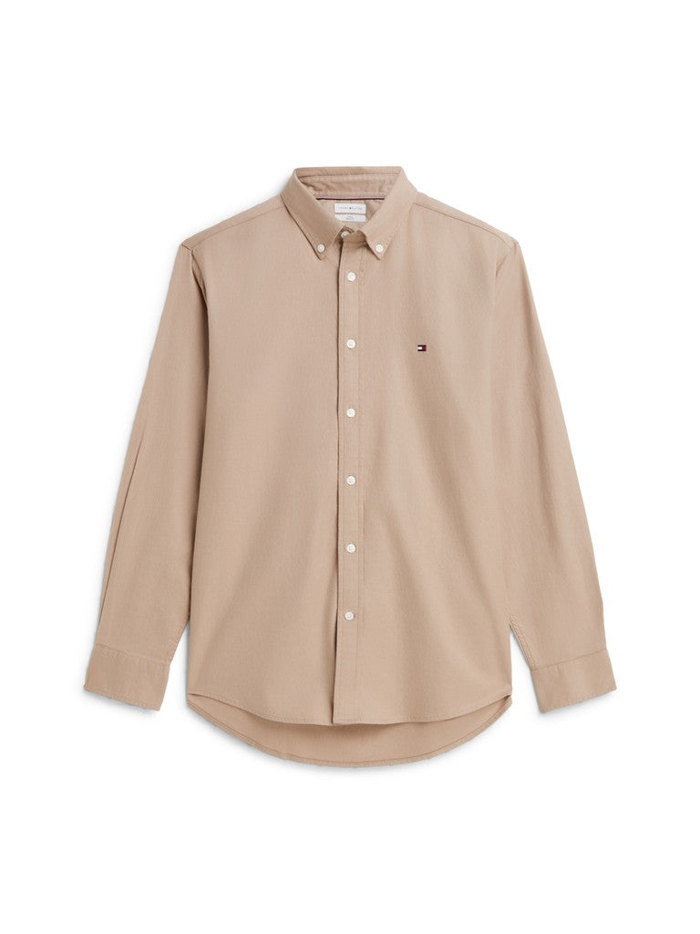A beige long-sleeve button-down shirt with a small embroidered Tommy Hilfiger flag logo on the left chest, displayed on a clean white background.