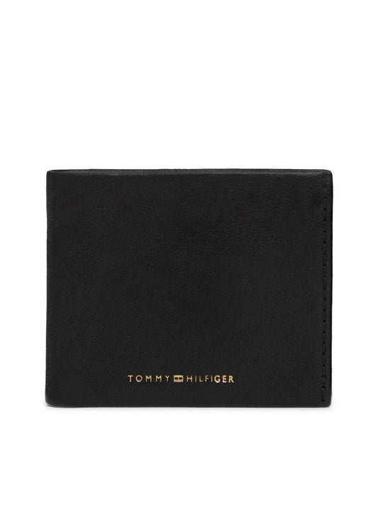 A black leather bifold wallet with gold-toned 'TOMMY HILFIGER' branding on the front, shown against a plain white background.