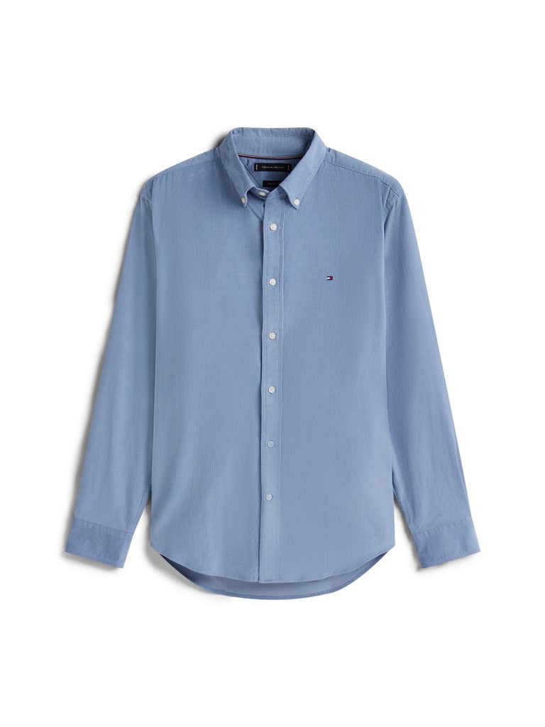 A light blue long-sleeve button-down shirt with a small embroidered Tommy Hilfiger flag logo on the left chest, displayed on a clean white background.