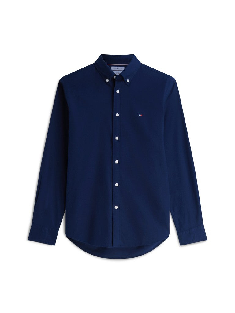 A navy blue long-sleeve button-down shirt with white buttons and a small embroidered Tommy Hilfiger flag logo on the left chest, displayed on a clean white background.