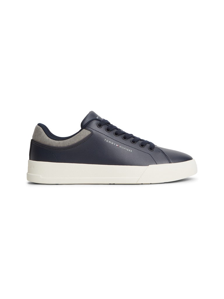 A low-top navy sneaker with a thick white platform sole, black laces, and a white heel tab, shown in a side profile on a light gray background.