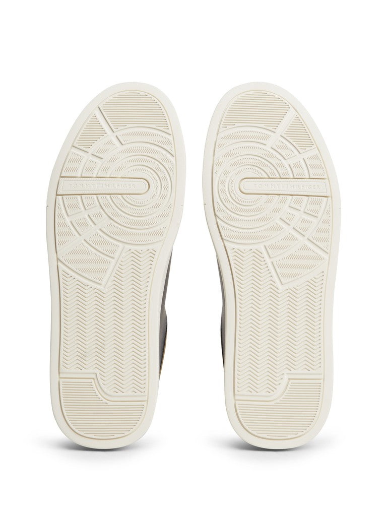 A pair of off-white sneakers shown from the sole view, displaying detailed tread patterns on a clean white background.