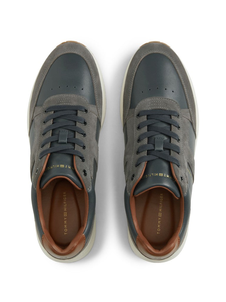 Pair of Tommy Hilfiger leather suede lace up sneakers top down view with Tommy Hilfiger logo in gold lettering. Navy and grey panes with brown details
