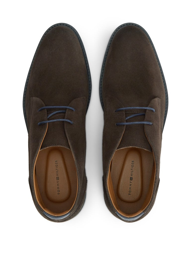 A pair of dark brown suede ankle boots with blue laces, shown from a top-down view on a white background. The brand name 'TOMMY HILFIGER' is visible on the tan insoles.
