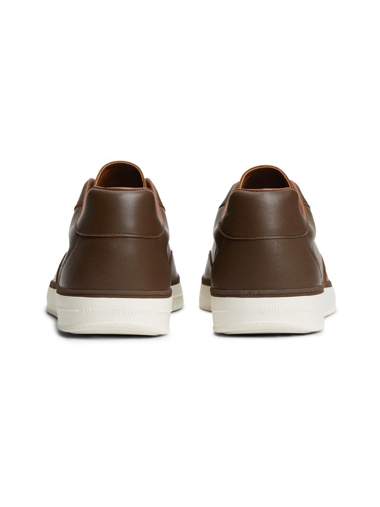 A pair of brown leather low-top sneakers shown from the back, featuring a thick white sole with debossed branding.