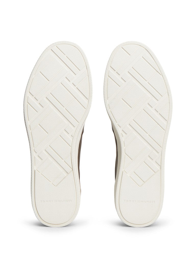 The soles of a pair of shoes shown from the bottom, featuring a textured geometric pattern in off-white and cream tones.