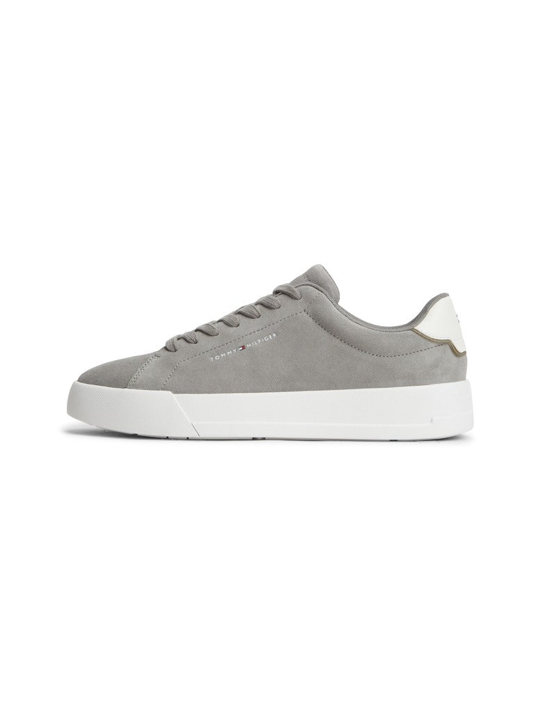 Gray athletic shoe with Tommy Hilfiger logo on the side and white sole on a white background