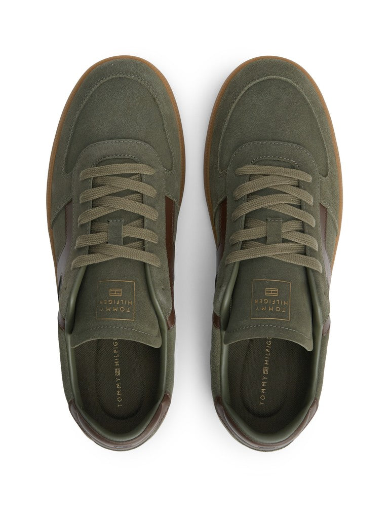 A pair of low-top suede sneakers in olive green with brown side panels and brown laces, shown from a top-down view on a white background.