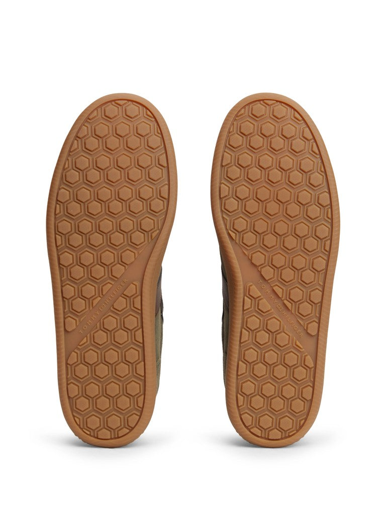 A pair of brown shoes shown from the bottom, displaying their textured honeycomb-patterned rubber soles against a plain white background.
