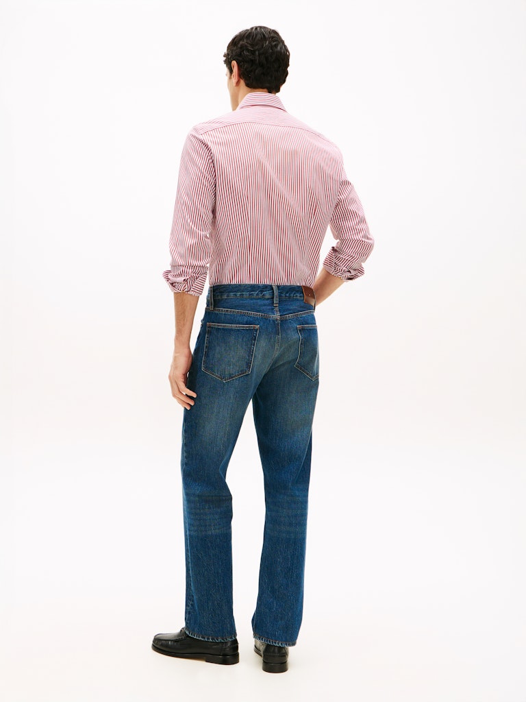 Person wearing a pink striped shirt and blue jeans on a white background