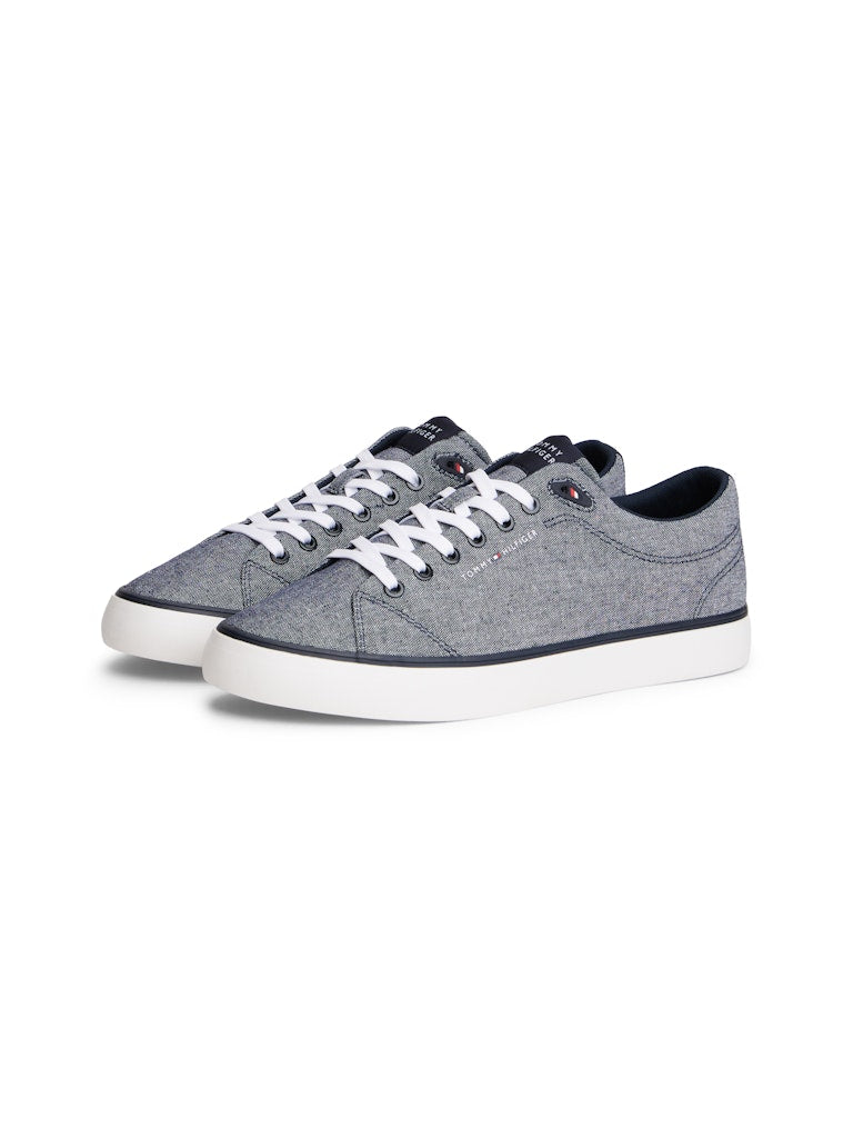 Side view of canvas lace up casual shoes in a blue grey colour with white sole and a Tommy Hilfiger logo on the side