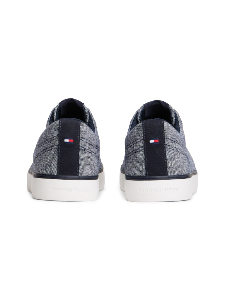 Heel view of canvas lace up casual shoes in a blue grey colour with white sole and a Tommy Hilfiger logo on the back