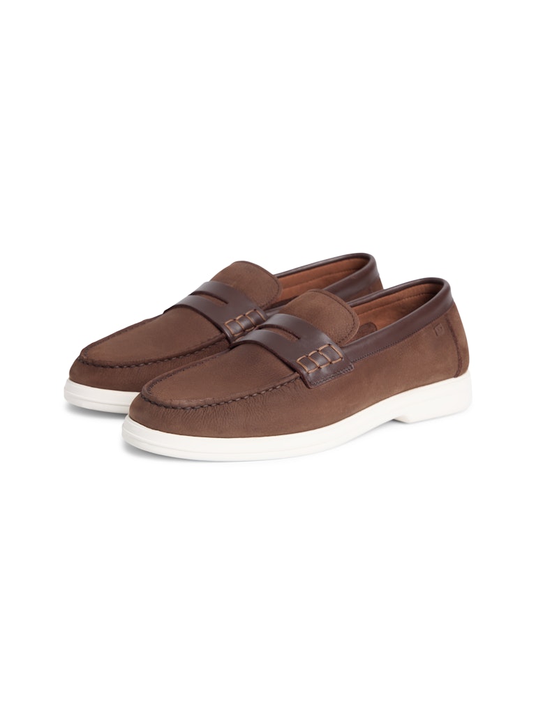 Side view of brown leather loafers with white sole and small Tommy Hilfiger flag outline logo in metal