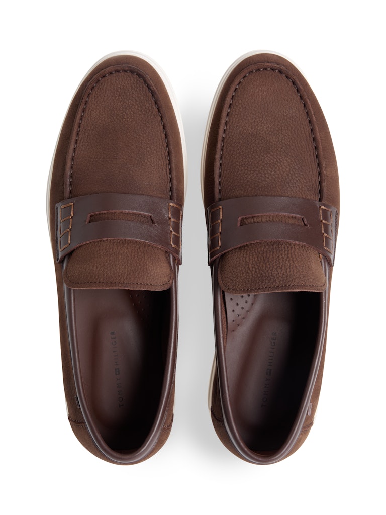 Top down view of brown leather loafers with white sole and small Tommy Hilfiger logo