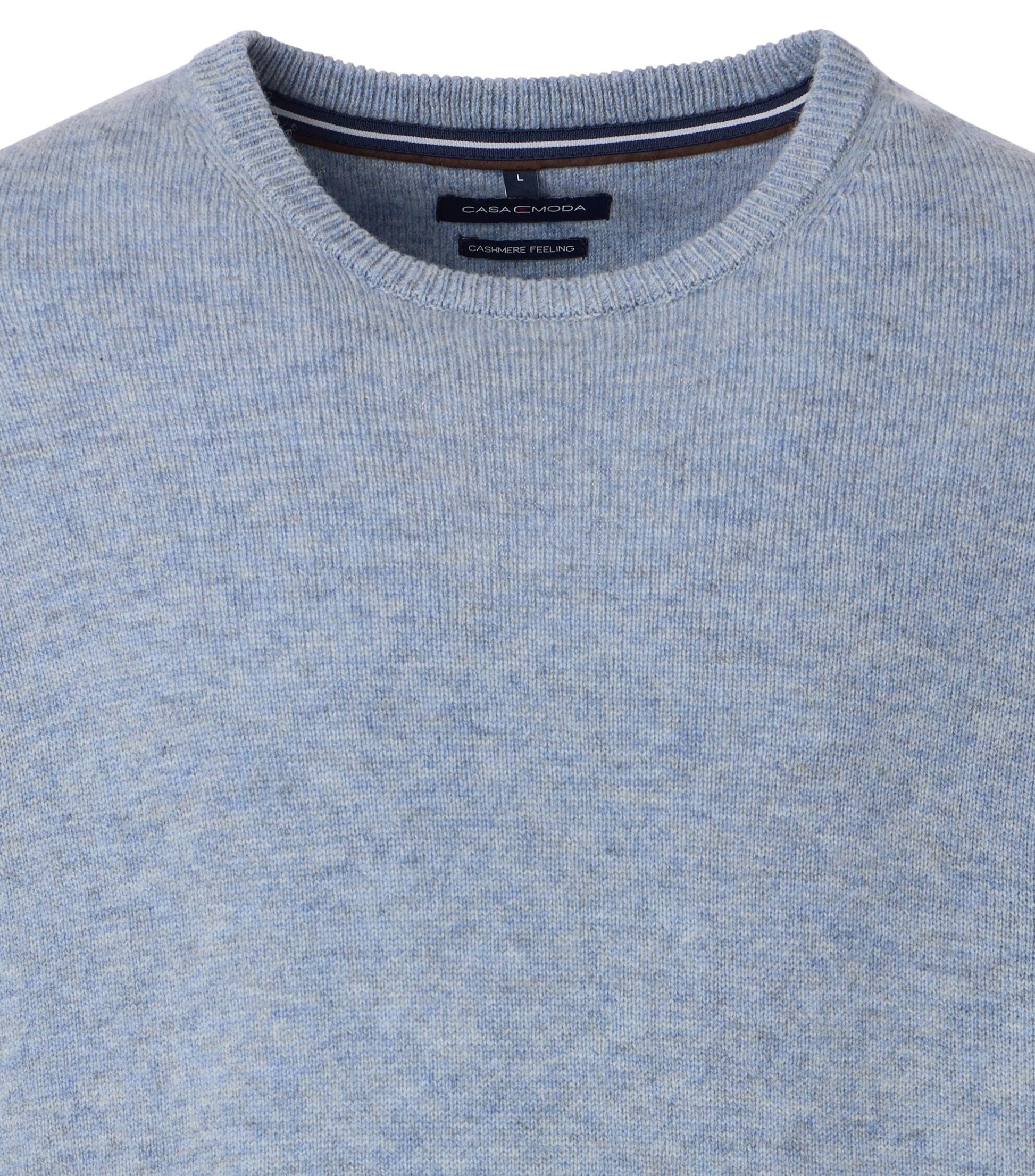 Close-up of a blue sweater with a CasaModa brand label on a white background
