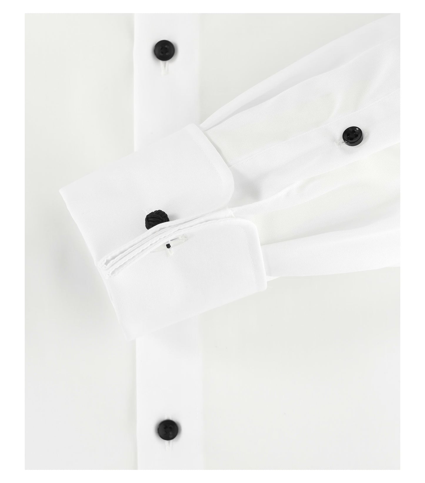 Close-up of a white shirt with a double cuff and black buttons on a white background