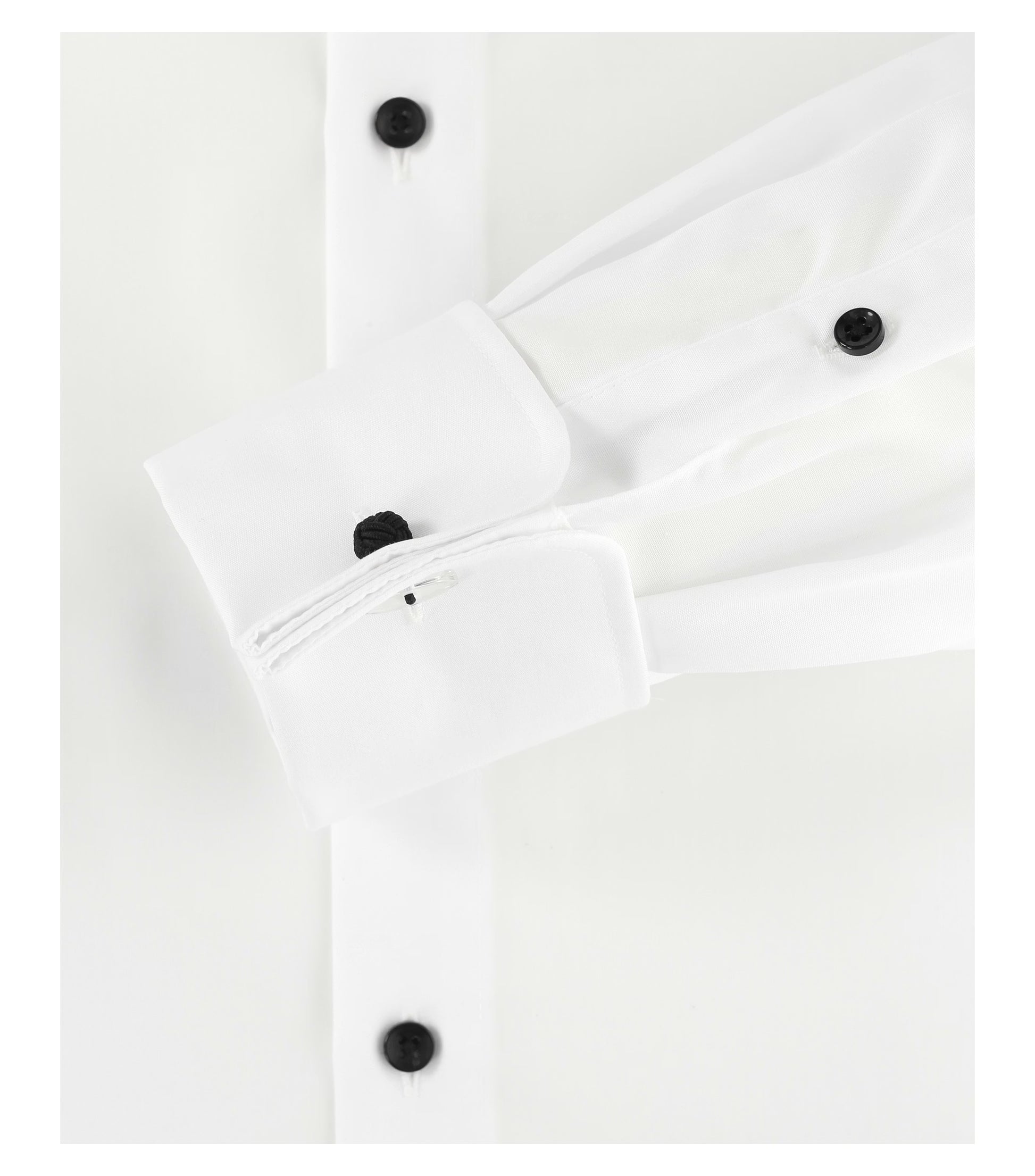 Close-up of a white shirt with a double cuff and black buttons on a white background