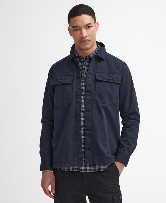 Barbour International Arlo Overshirt. Man wearing a navy overshirt over a plaid shirt on a white background - Matt O'Brien Fashions